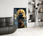 tall sailing ship before a full moon glass wall art leaning beside a dark leather sofa
