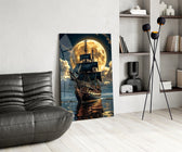tall sailing ship before a full moon glass wall art leaning beside a dark leather sofa