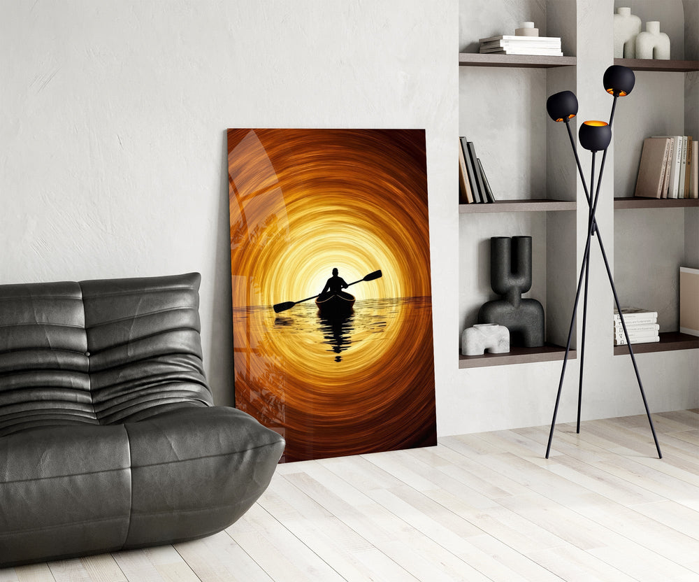 a lone kayaker at golden sunset glass wall art leaning beside a dark leather sofa