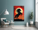 a rearing black horse under a red moon glass wall art styled above an armchair in a reading corner