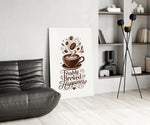 a latte-art coffee cup with hand lettering glass wall art leaning beside a dark leather sofa