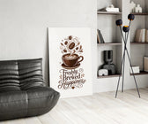 a latte-art coffee cup with hand lettering glass wall art leaning beside a dark leather sofa
