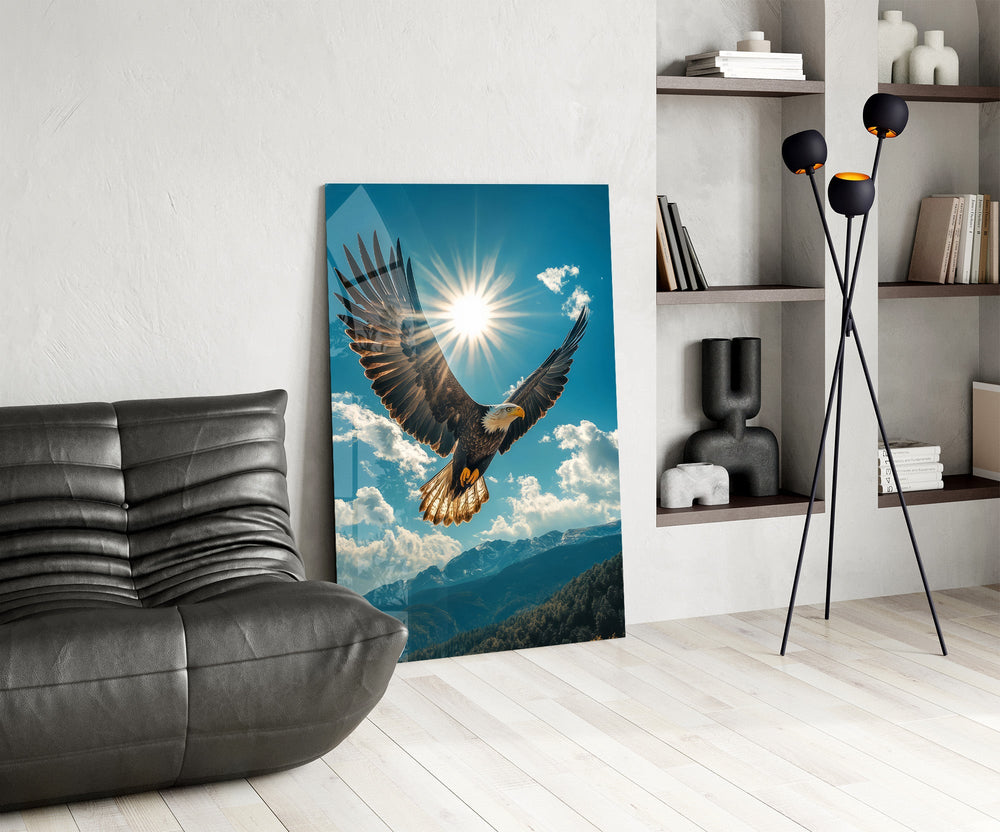 a bald eagle before a bright sunburst glass wall art leaning beside a dark leather sofa