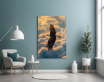 a bald eagle soaring above golden clouds glass wall art styled above an armchair in a reading corner