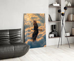 a bald eagle soaring above golden clouds glass wall art leaning beside a dark leather sofa