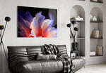 an abstract flower with translucent petals glass wall art styled above an armchair in a reading corner