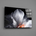 an abstract white flower on black glass wall art angled to show the polished tempered glass panel