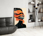 windswept orange hair over a blue-toned portrait glass wall art leaning beside a dark leather sofa