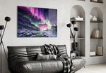 northern lights over a snowy mountain valley glass wall art styled above an armchair in a reading corner