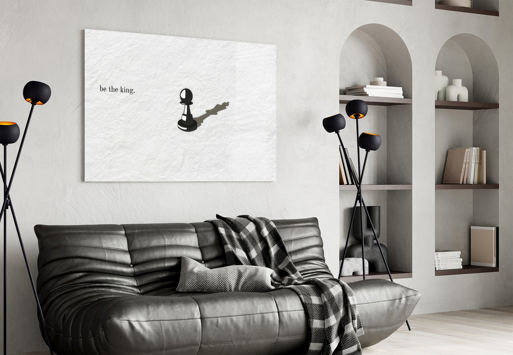 chess pawn casting a king shadow glass wall art styled above an armchair in a reading corner