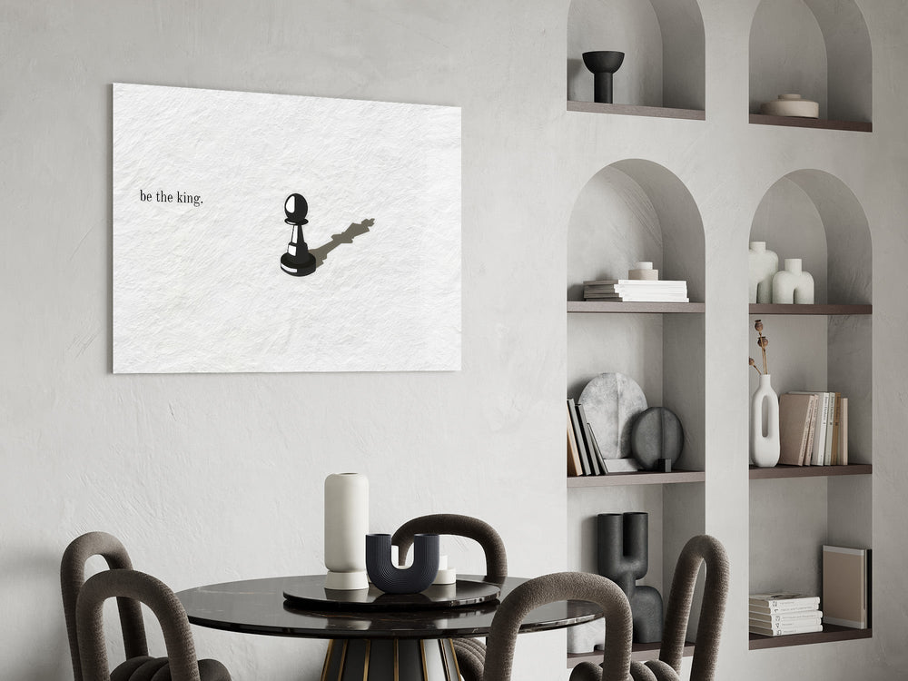 chess pawn casting a king shadow glass wall art leaning beside a dark leather sofa