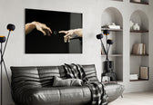two reaching hands with a loading spinner glass wall art styled above an armchair in a reading corner