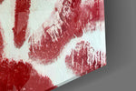 Close-up detail of the overlapping crimson lip impressions on cream on the glass surface