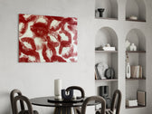 red lipstick kiss prints glass wall art leaning beside a dark leather sofa