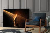 a hand reaching into a golden light beam panel resting in a shelving niche in a modern interior