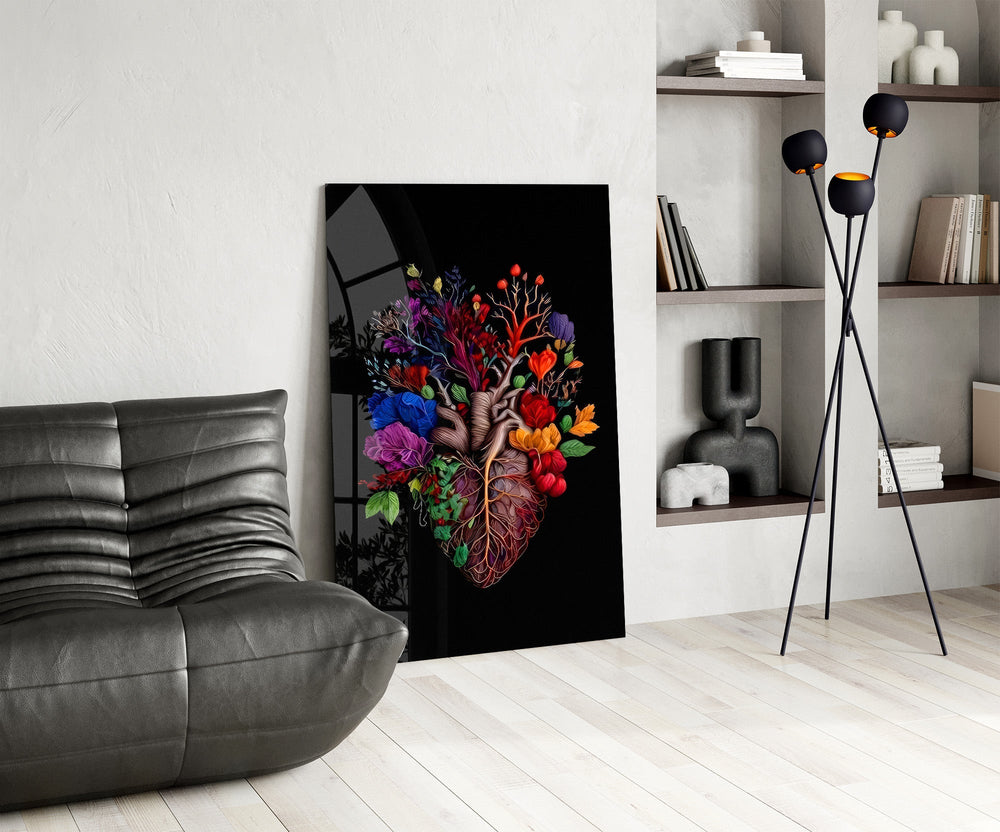 floral anatomical heart glass wall art leaning beside a dark leather sofa