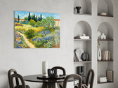 impressionist flower garden with a path glass wall art leaning beside a dark leather sofa