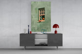 a reader lounging on a windowsill glass wall art styled in an atmospheric room setting