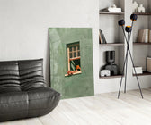 a reader lounging on a windowsill glass wall art leaning beside a dark leather sofa