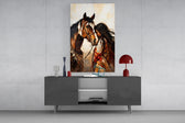 a native woman resting against her horse glass wall art styled in an atmospheric room setting