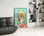 a woman crowned with wildflowers glass wall art leaning beside a dark leather sofa
