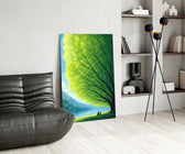 two friends beneath a sprawling tree glass wall art leaning beside a dark leather sofa