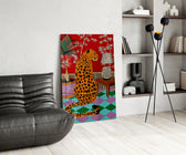 spotted leopard in a bold interior glass wall art leaning beside a dark leather sofa