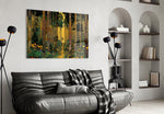 golden forest path through patterned trunks glass wall art styled above an armchair in a reading corner