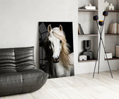 white horse portrait on black glass wall art leaning beside a dark leather sofa