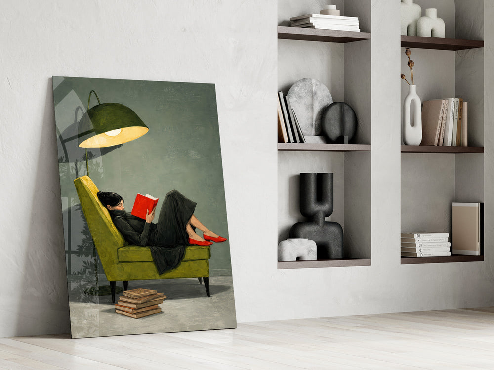 woman reading in a green armchair panel resting in a shelving niche in a modern interior