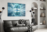 frozen turquoise tree in a winter landscape glass wall art styled above an armchair in a reading corner