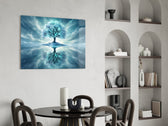 frozen turquoise tree in a winter landscape glass wall art leaning beside a dark leather sofa