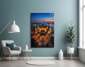 twilight aerial view of an illuminated mosque glass wall art styled above an armchair in a reading corner