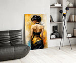 Woman in black and gold gown glass wall art leaning beside a sofa in a warm interior