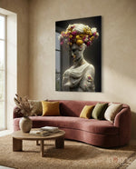 Abandoned Statue glass wall art displayed above a rose-velvet sofa in a warm living room with travertine console and woven floor rug
