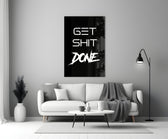 Typographic artwork anchoring a desk wall with white-on-onyx palette