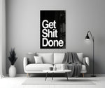 Get Shit Done glass wall art styled above a console in a study