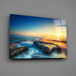 Close-up detail of wet rocks and silky turquoise surf at sunrise