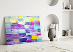 Abstract glass wall art styled above a bed in a soft, feminine bedroom