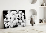 Flower glass wall art styled above a bed in a modern, refined bedroom