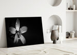 Flower glass wall art styled above a bed in a modern, refined bedroom