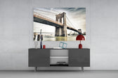 Fine art long exposure photography – Brooklyn Bridge stone tower and steel cables in warm muted tones over mirror-calm East River