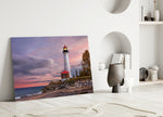 Lighthouse glass wall art styled above a bed in a coastal-inspired bedroom