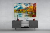 Fine art photography – vibrant autumn lakeside with golden and russet foliage reflected in glassy calm water, dramatic blue sky overhead