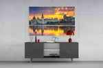 Fine art photography – Prague historic waterfront at dramatic golden sunset, colorful spired buildings reflected in mirror-calm Vltava River