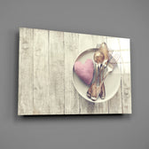 Close-up detail of silver cutlery and pink fabric heart on wood