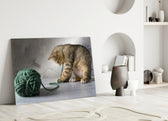 Close-up detail of the tabby kitten playing with green yarn
