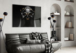 Woman glass wall art styled above a bed in a black-and-gold bedroom