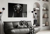 Woman glass wall art styled above a bed in a black-and-gold bedroom