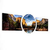 A panoramic mountain valley with golden-lit granite cliffs, a winding river, and a dense pine forest under a dramatic blue sky. 3 piece glass wall art set D